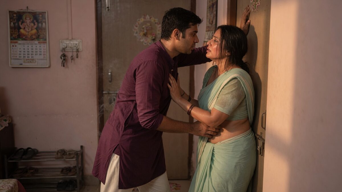 Two fully clothed adults, one adult Indian man and one adult Indian woman in an Indian apartment entry.