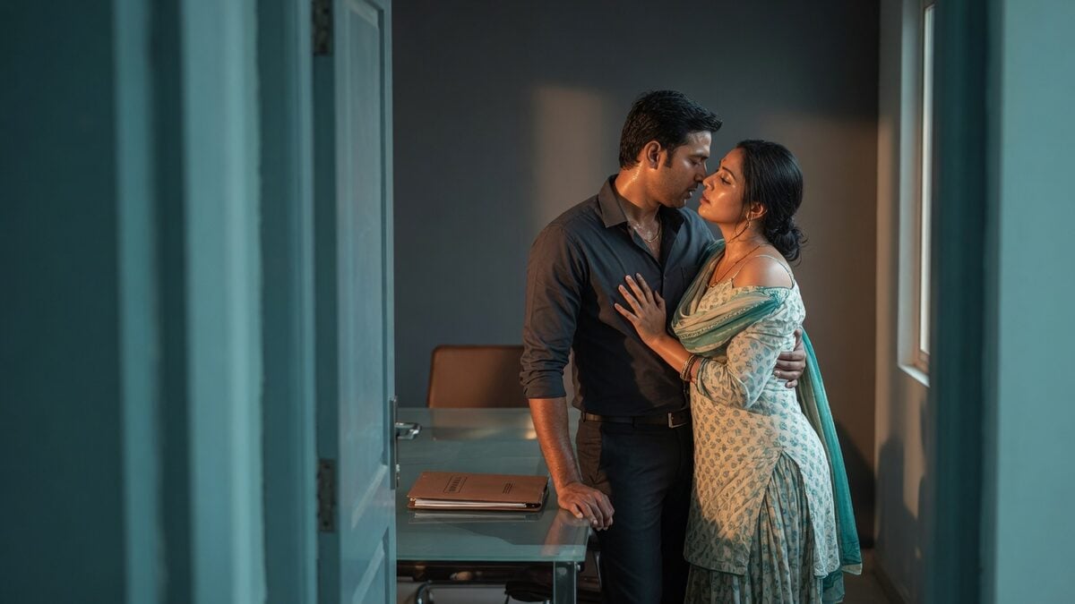 Two fully clothed adults, one adult Indian man and one adult Indian woman in a quiet modern meeting room.
