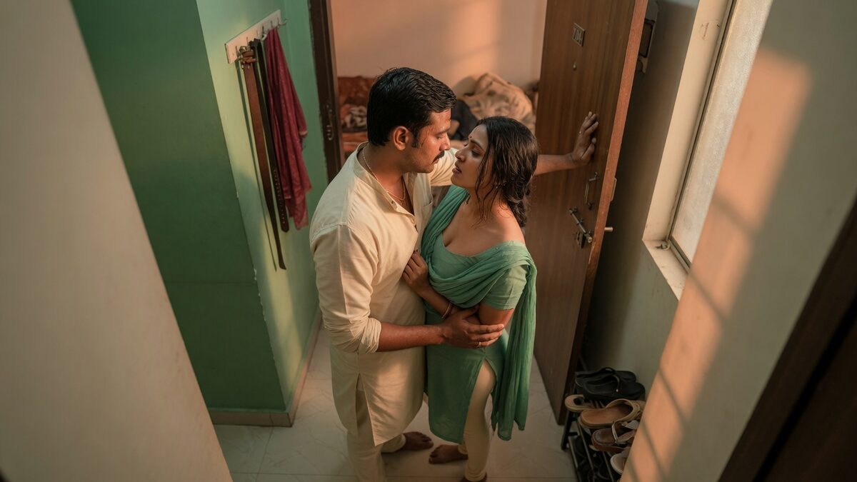 Two fully clothed adults, one adult Indian man and one adult Indian woman in a contemporary Indian city apartment entry.