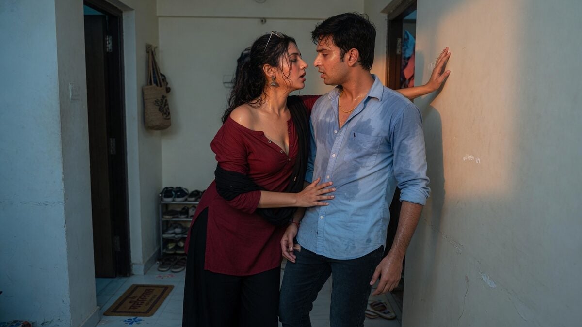 Two fully clothed adults, one adult Indian man and one adult Indian woman in an Indian apartment entry.