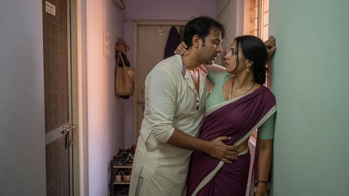 Two fully clothed adults, one adult Indian woman and one adult Indian man in a contemporary Indian city apartment entry.