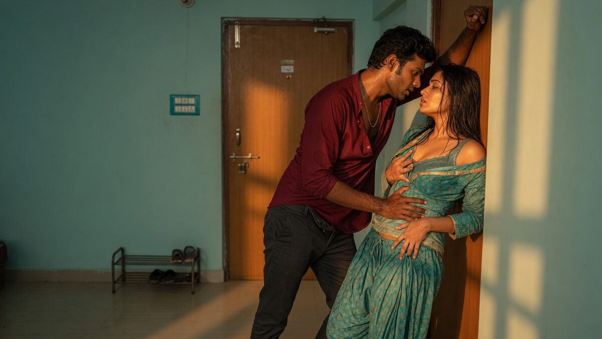 Two fully clothed adults, one adult Indian man and one adult Indian woman in an Indian apartment entry.