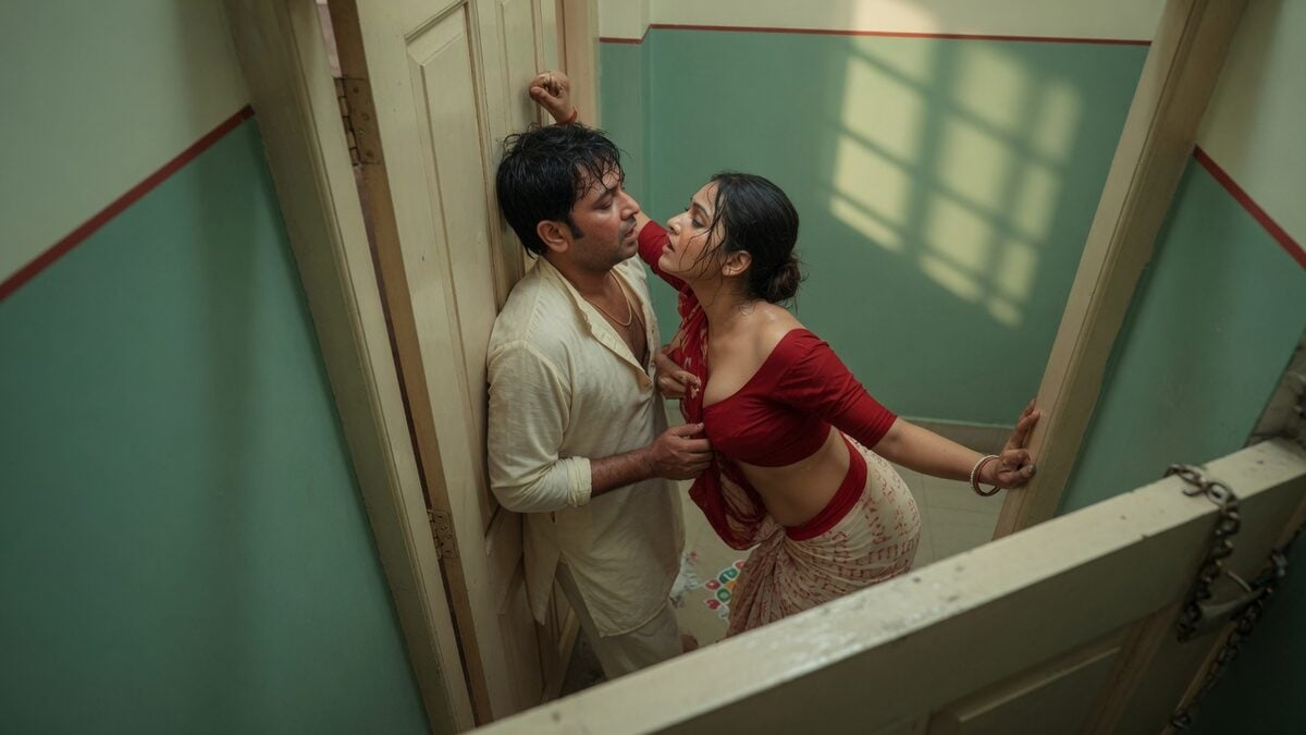 Two fully clothed adults, one adult Indian man and one adult Indian woman in a contemporary Indian city apartment entry.