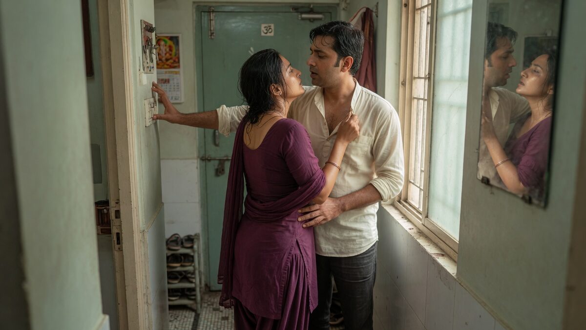 Two fully clothed adults, one adult Indian man and one adult Indian woman in an Indian apartment entry.