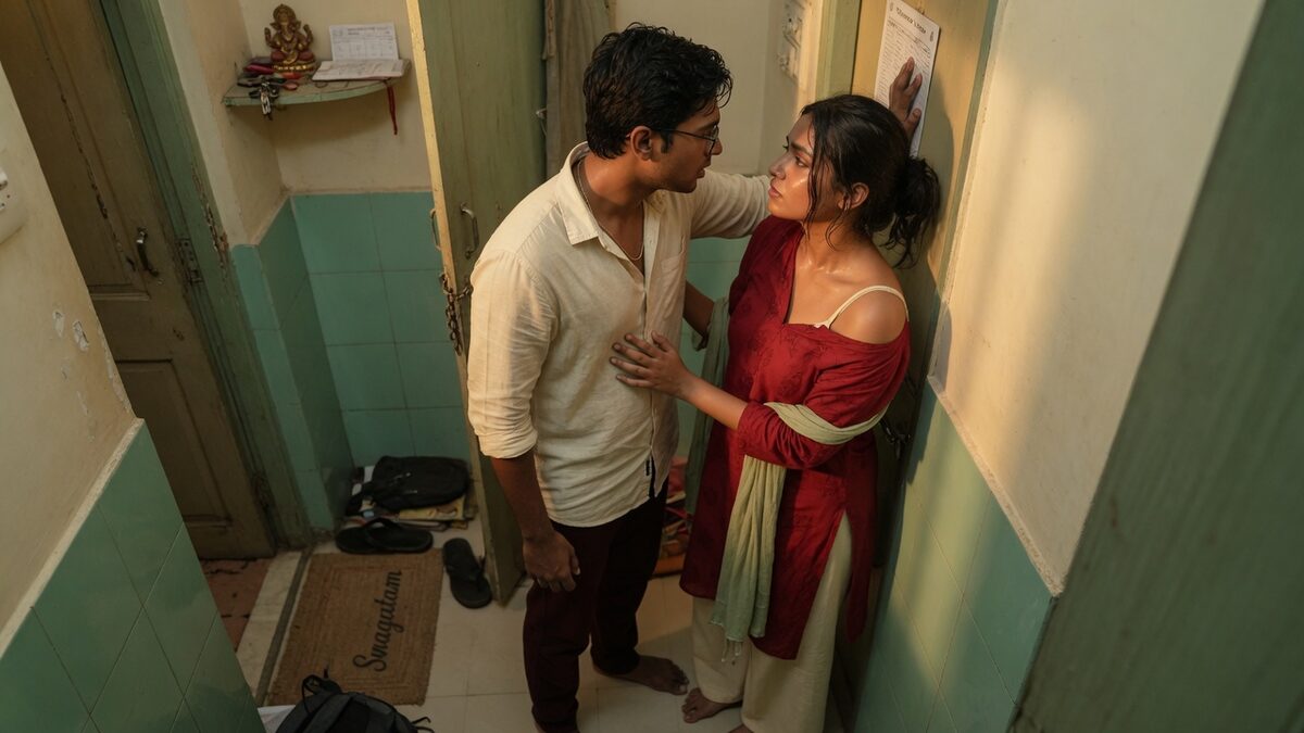 Two fully clothed adults, one adult Indian man and one adult Indian woman in an Indian apartment entry.