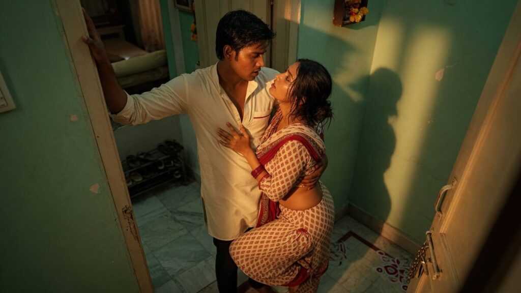 Two fully clothed adults, one adult Indian man and one adult Indian woman in an Indian apartment entry.