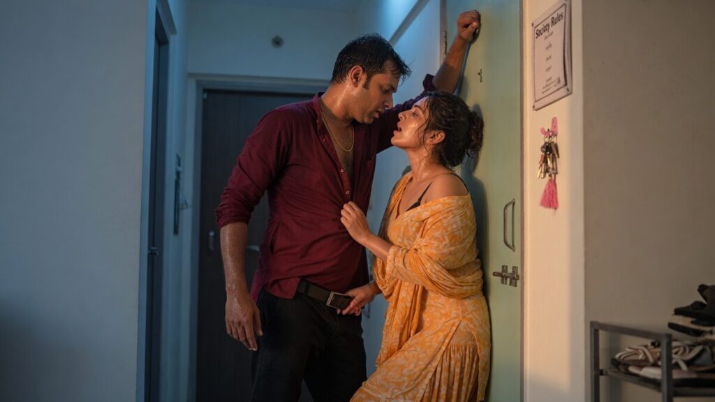 Two fully clothed adults, one adult Indian man and one adult Indian woman in a contemporary Indian city apartment entry.