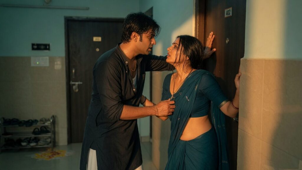 Two fully clothed adults, one adult Indian man and one adult Indian woman in a contemporary Indian city apartment entry.