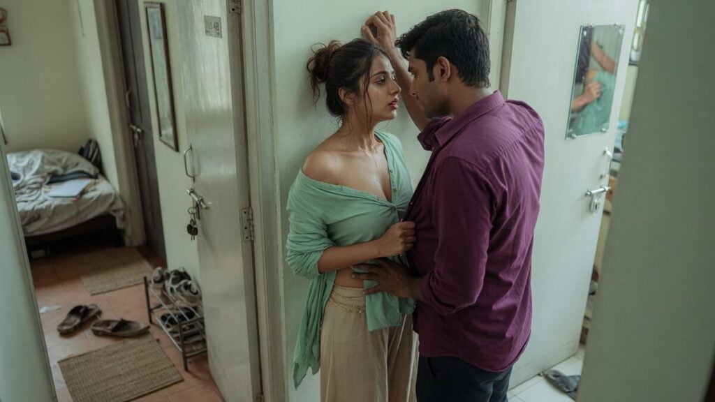 Two fully clothed adults, one adult Indian man and one adult Indian woman in an Indian apartment entry.