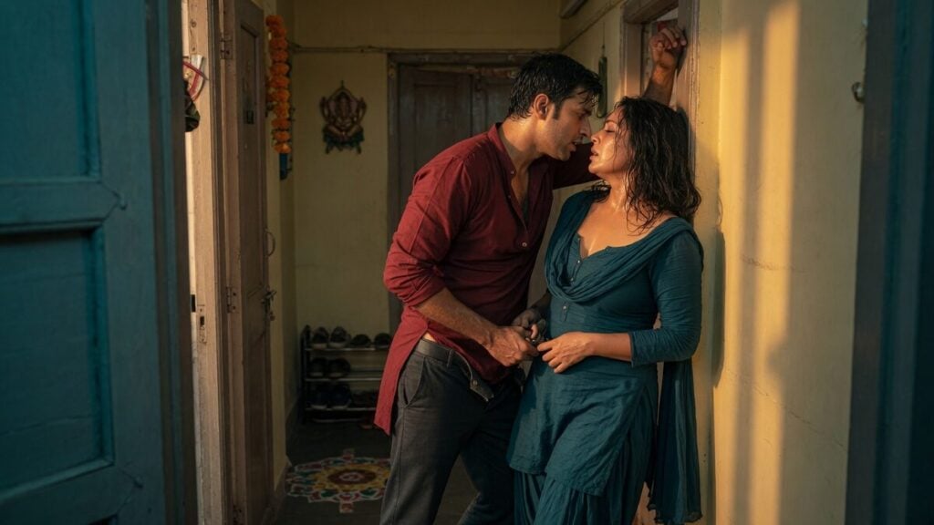 Two fully clothed adults, one adult Indian man and one adult Indian woman in an Indian apartment entry.