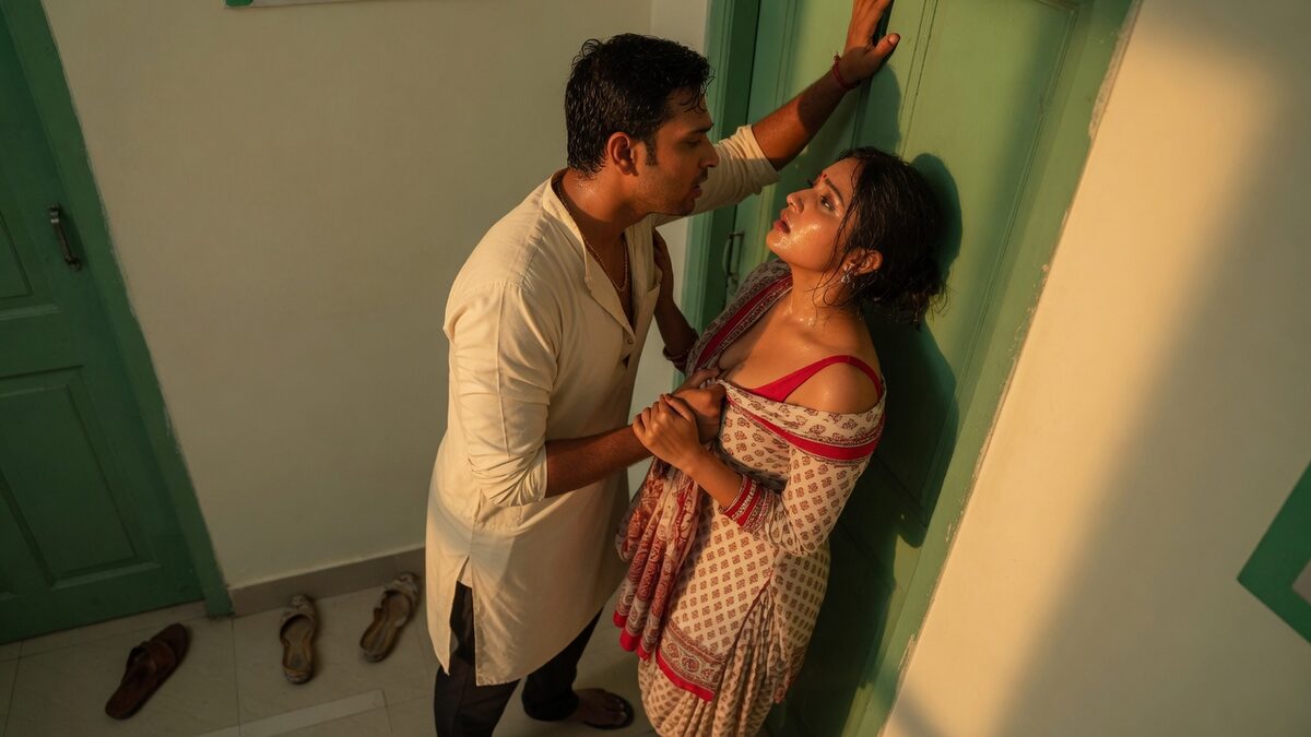 Two fully clothed adults, one adult Indian man and one adult Indian woman in an Indian apartment entry.