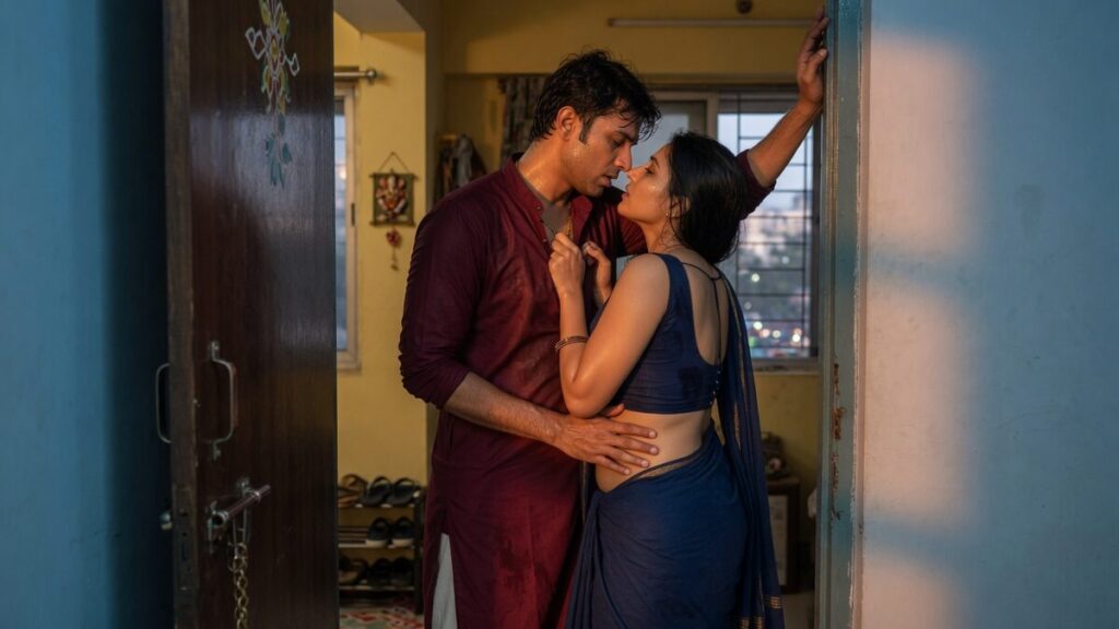 Two fully clothed adults, one adult Indian man and one adult Indian woman in a contemporary Indian city apartment entry.