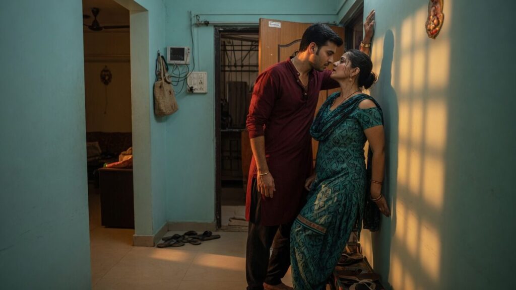 Two fully clothed adults, one adult Indian man and one adult Indian woman in an Indian apartment entry.