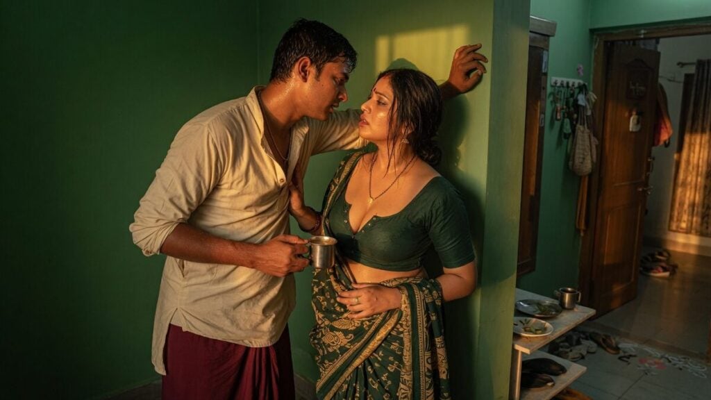 Two fully clothed adults, one adult Indian man and one adult Indian woman in an Indian apartment entry.