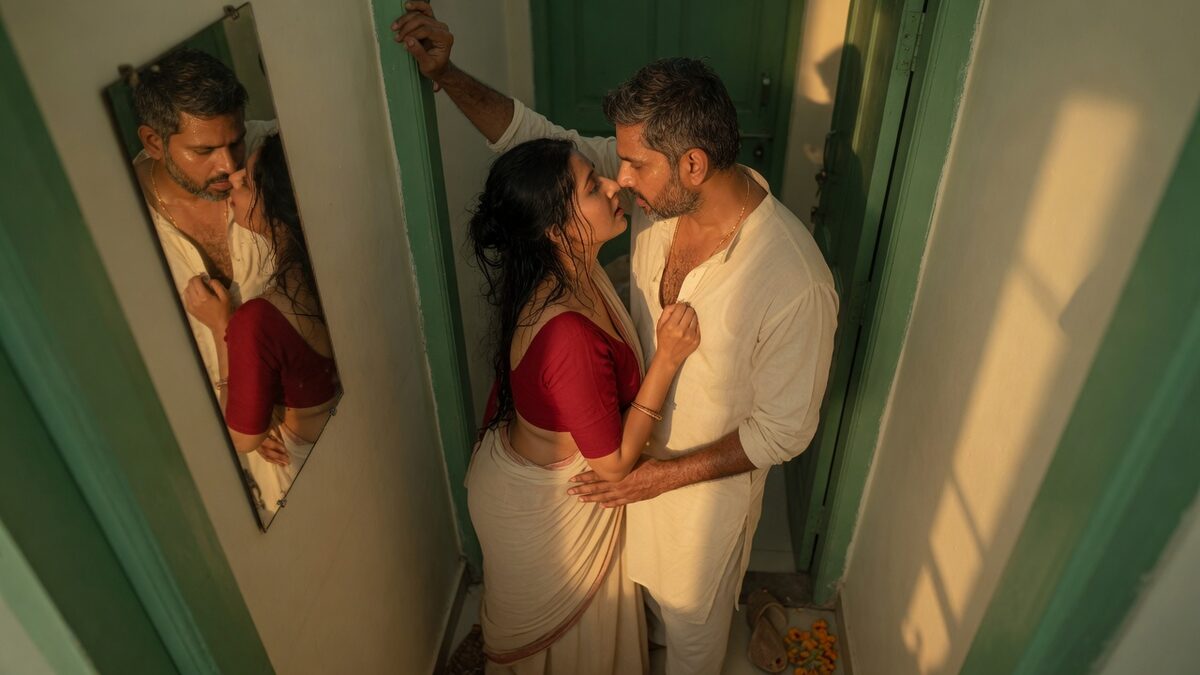 Two fully clothed adults, one adult Indian man and one adult Indian woman in an Indian apartment entry.