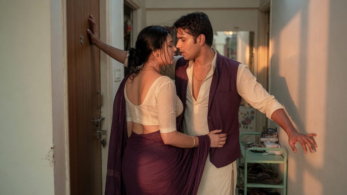 Two fully clothed adults, one adult Indian man and one adult Indian woman in a contemporary Indian city apartment entry.
